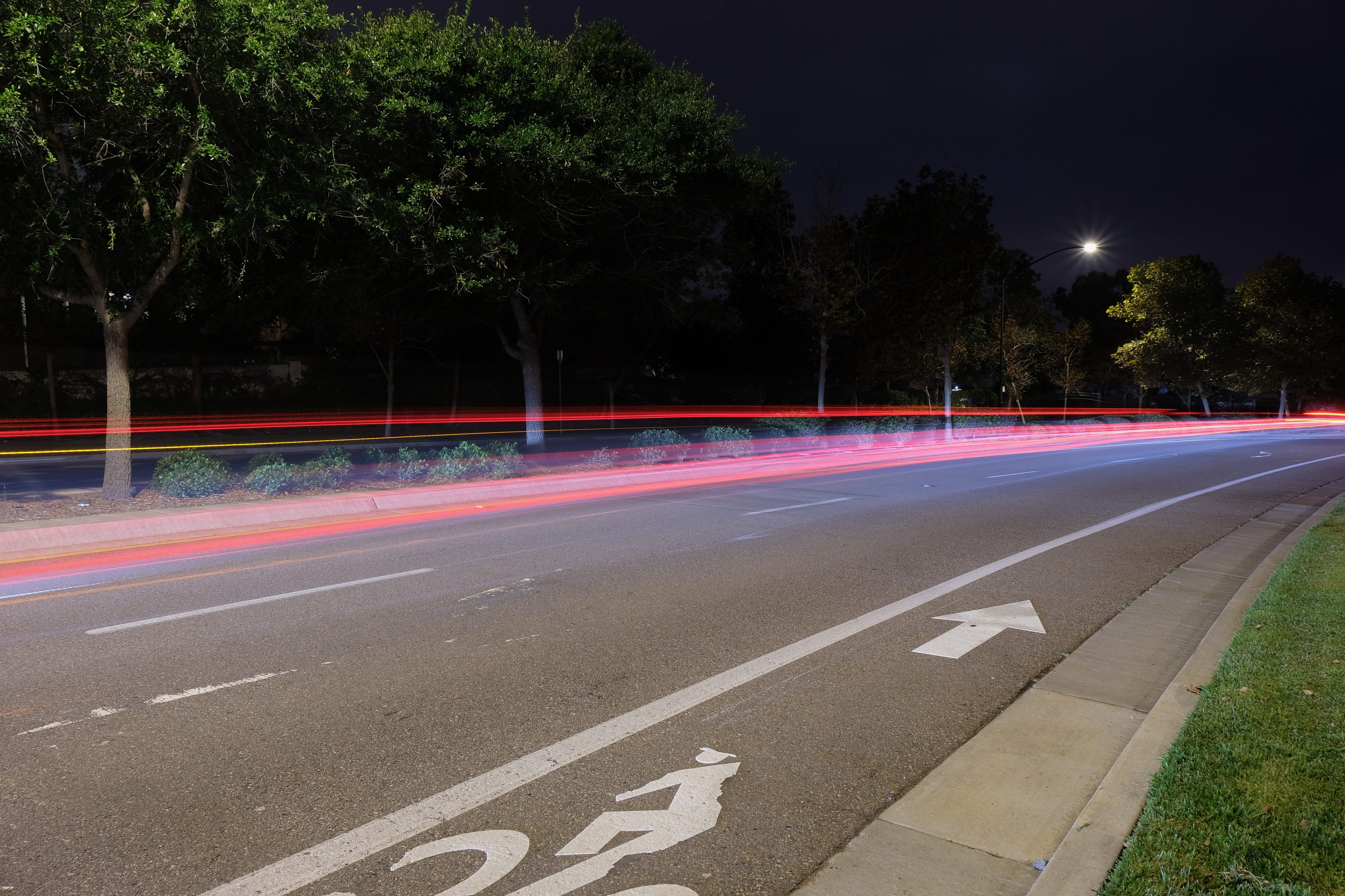 Light Trail — long-exposure photograph of red and white car light streaks on a road at night.
