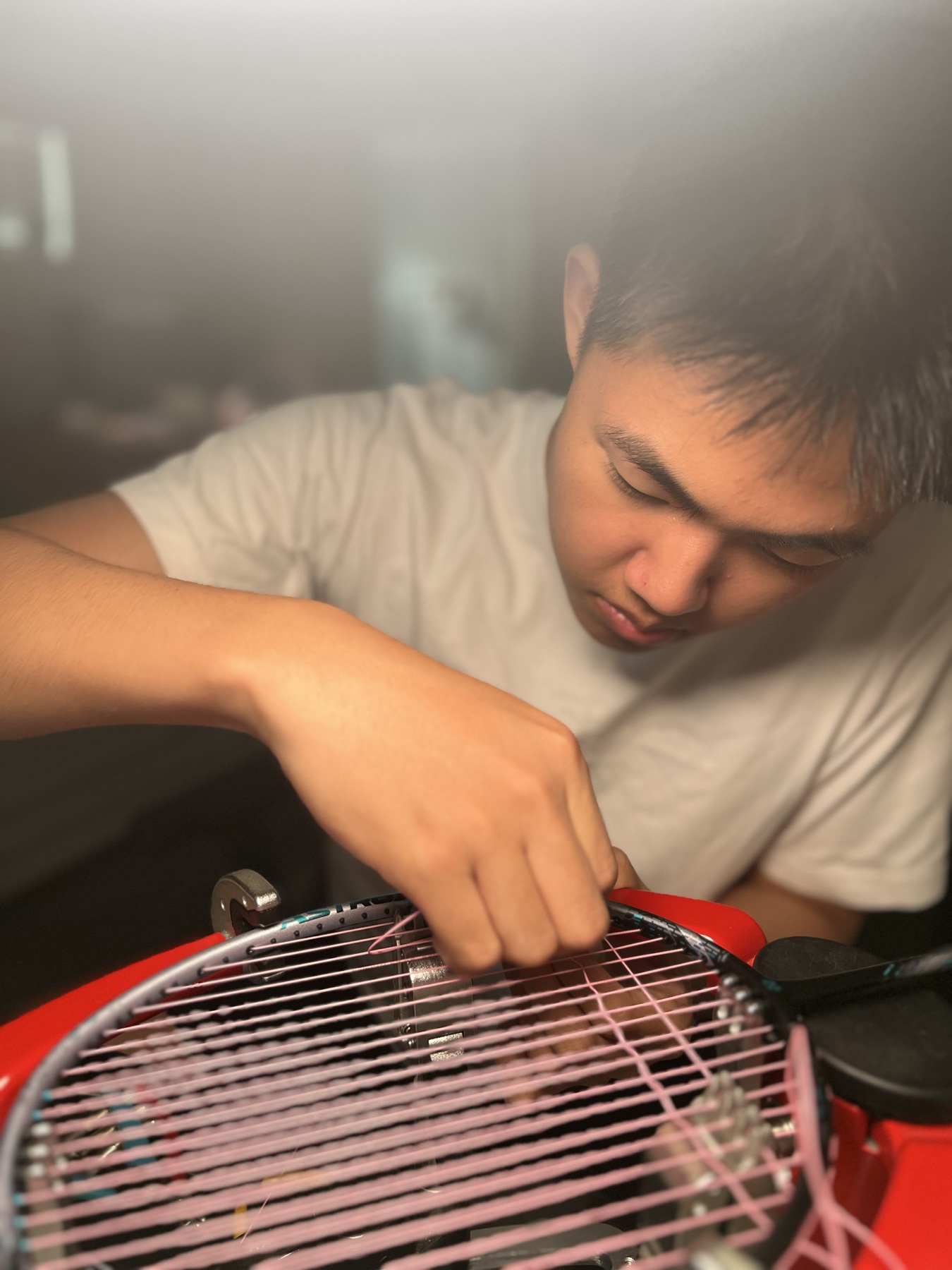 Keshu working on the strings of a badminton racket at home.